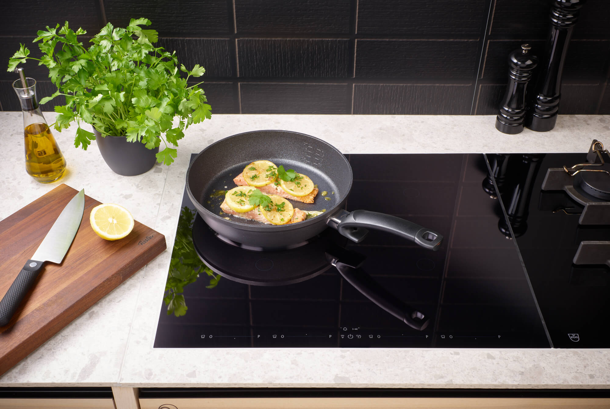 Fissler Adamant® Comfort Pfannenset (24 cm & 28 cm) auf dem Induktionskochfeld, frische Zutaten in Reichweite; deutsche Präzision seit 1845.