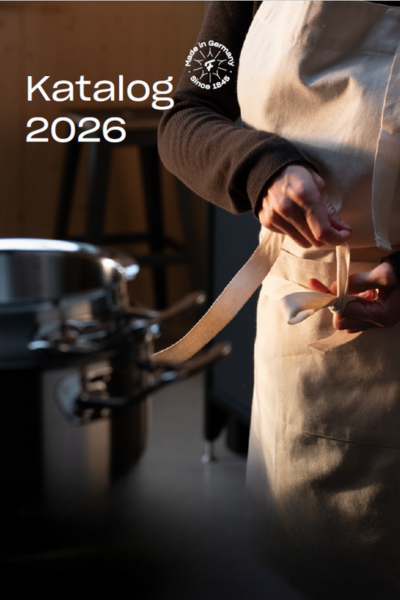 alt
A person in a white apron ties their waist near a Fissler stainless steel pot. "Catalog 2026" is in the upper left corner.