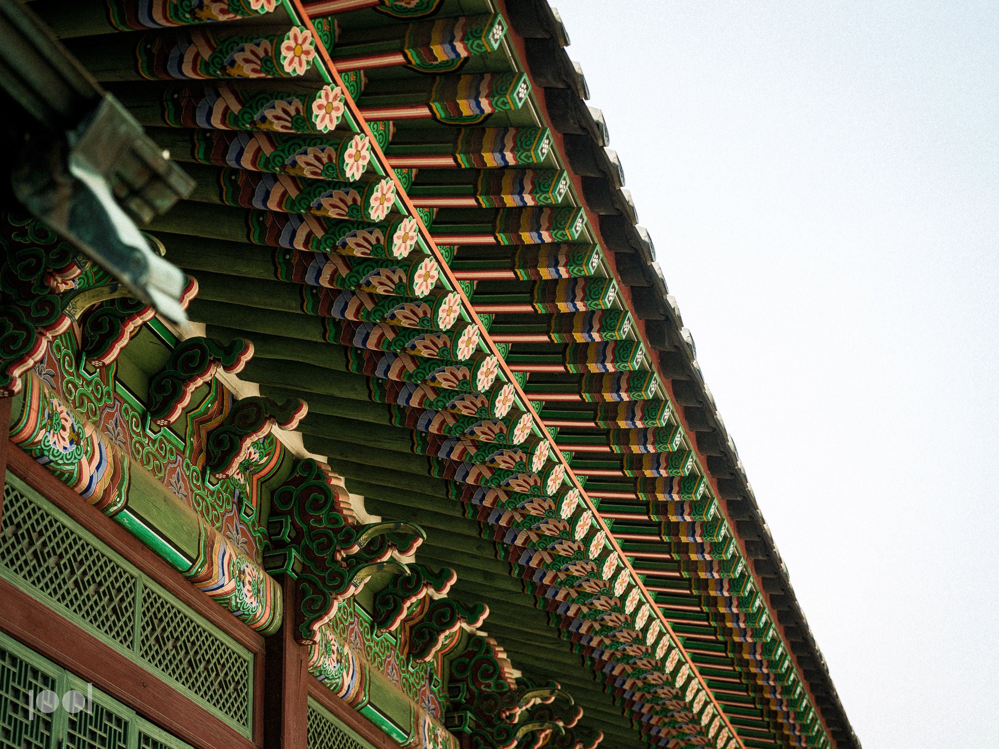Precision and artistry meet in this close-up view of the colorful, ornate eaves of a traditional Korean building, where detailed wooden carvings and patterns stand out elegantly against a clear sky—an inspiring display of craftsmanship reminiscent of Fissler’s commitment to high-quality German engineering in our cookware collections.